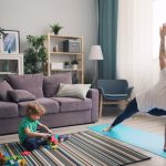 a woman and a child doing yoga in a living room