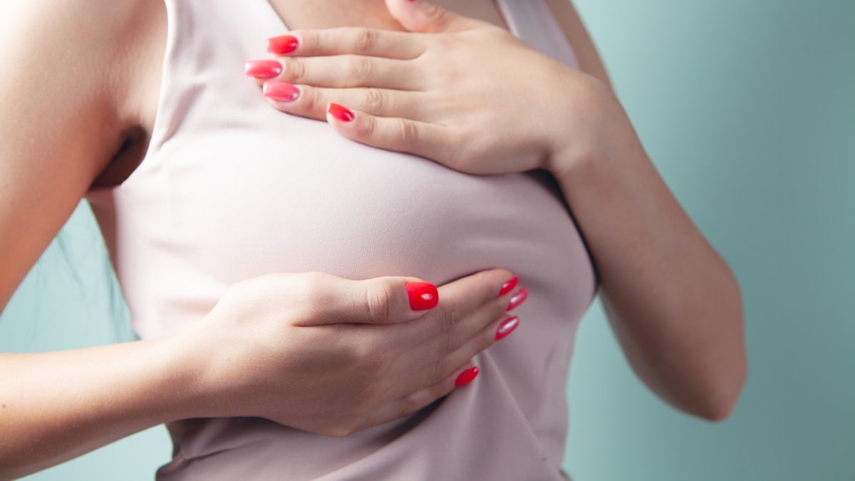 a woman with red nail polish holding her stomach